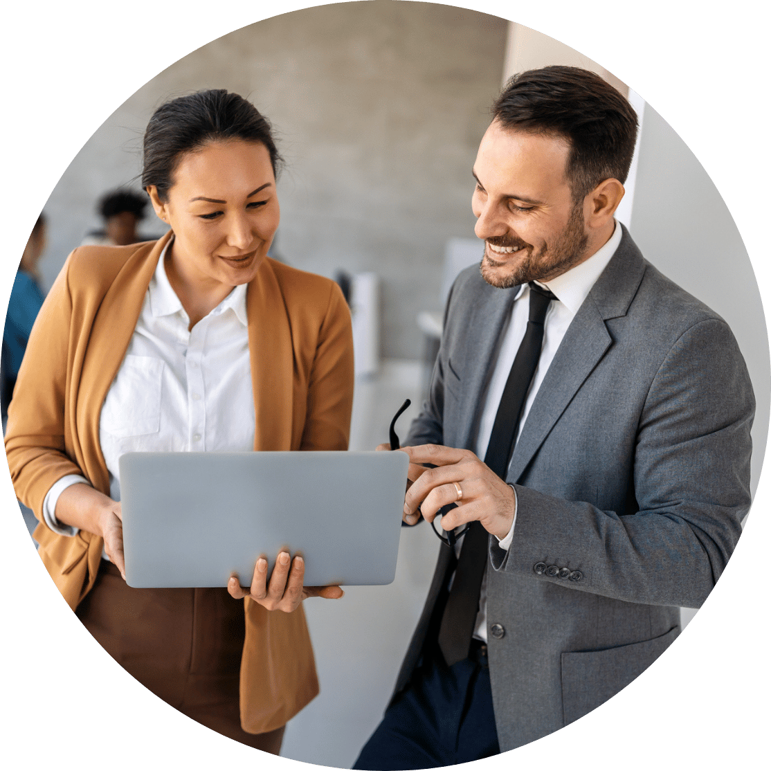 Two coworkers conversing around a laptop