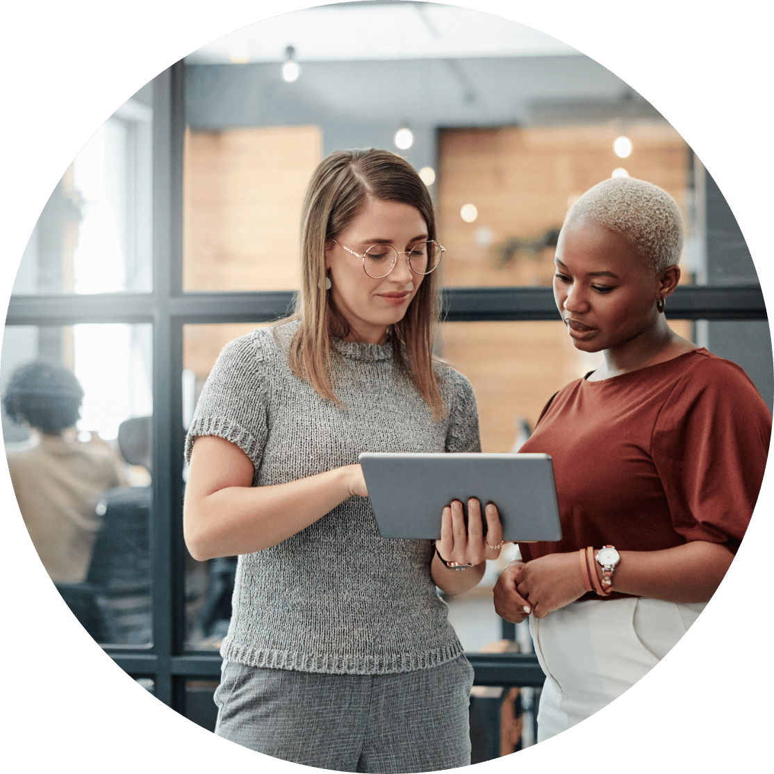Two coworkers discussing over a tablet
