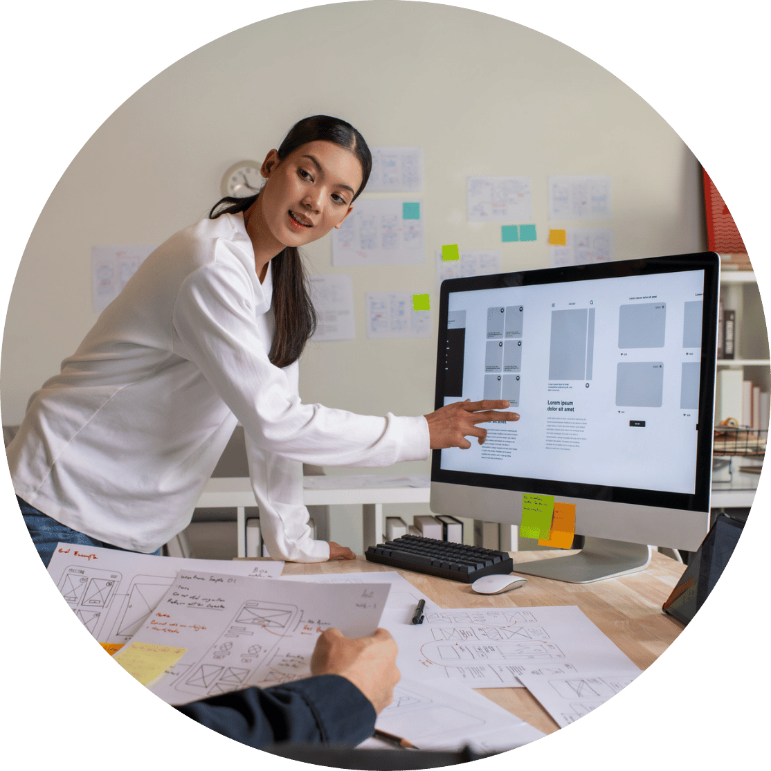 A woman pointing to a design file on a computer