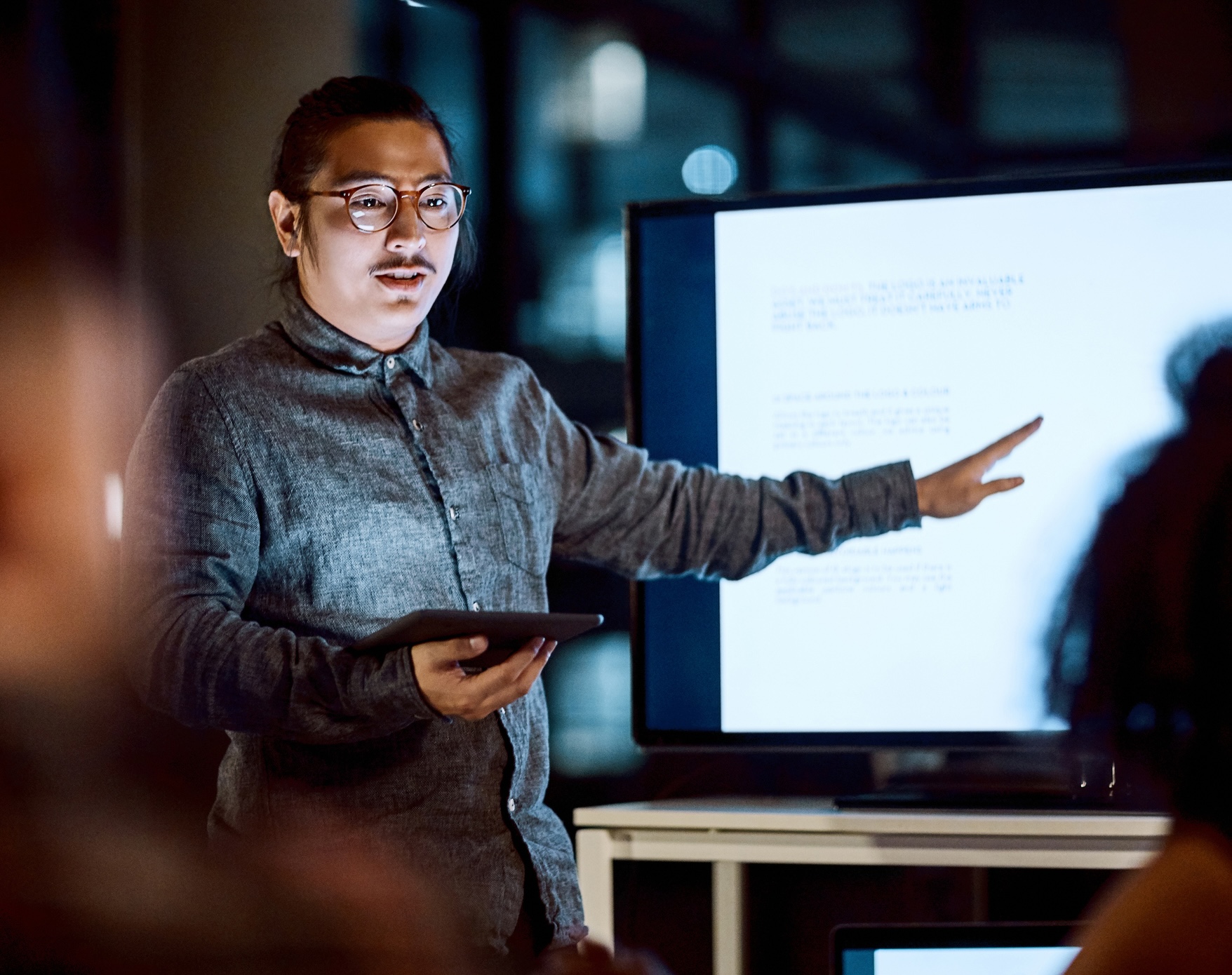 A person gesturing to a screen