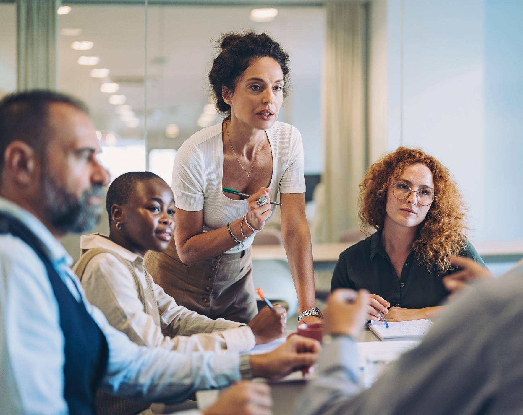 A woman speaking to coworkers in a meeting