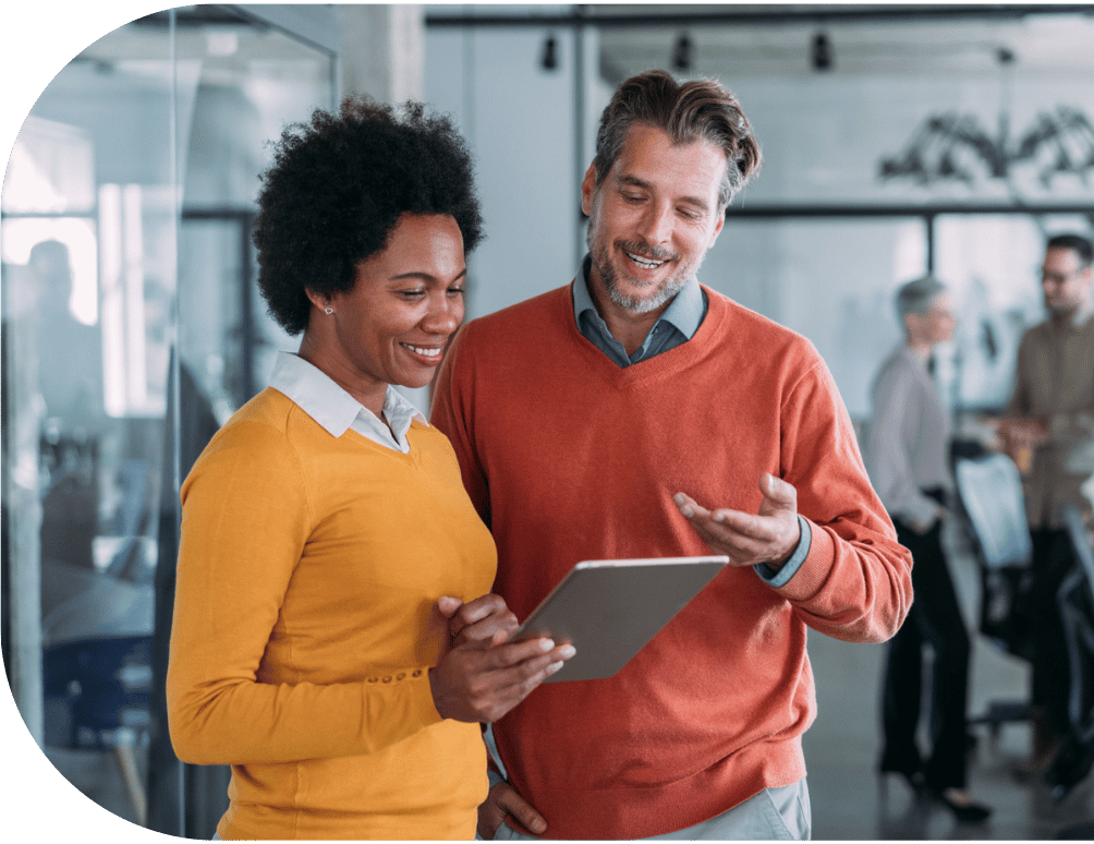 Two coworkers chatting over a tablet