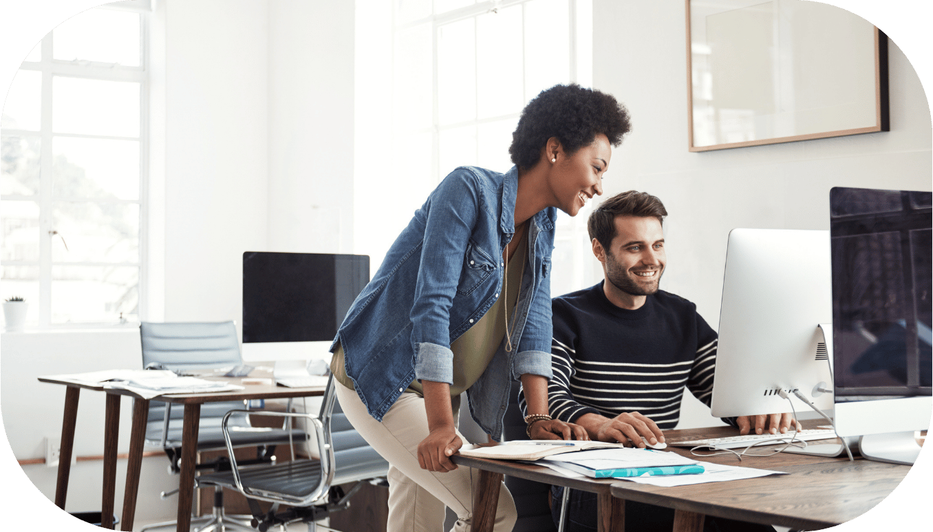 Two coworkers chatting at a desk