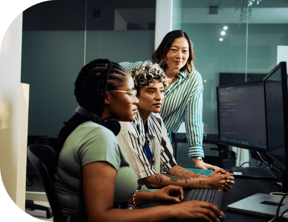 Three coworkers around a desktop