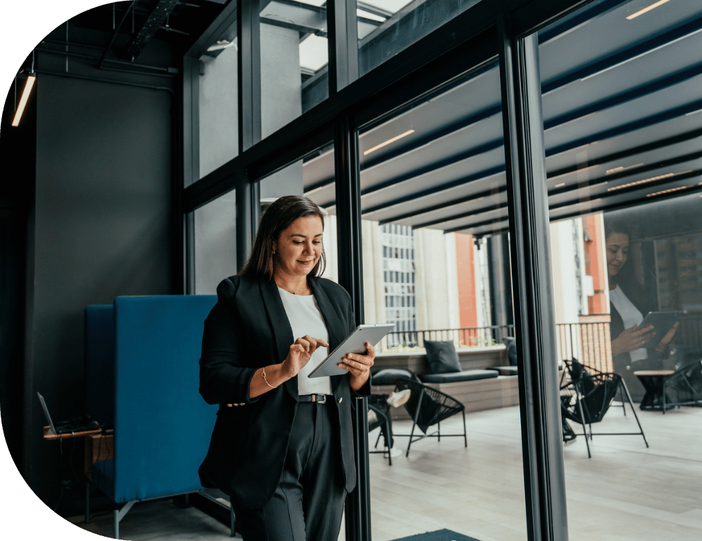 A woman walking and looking at a tablet