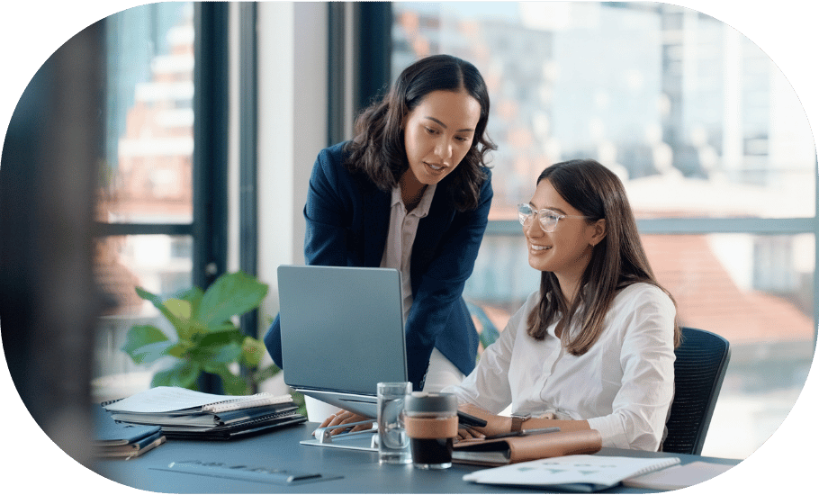 Two coworkers looking at a laptop