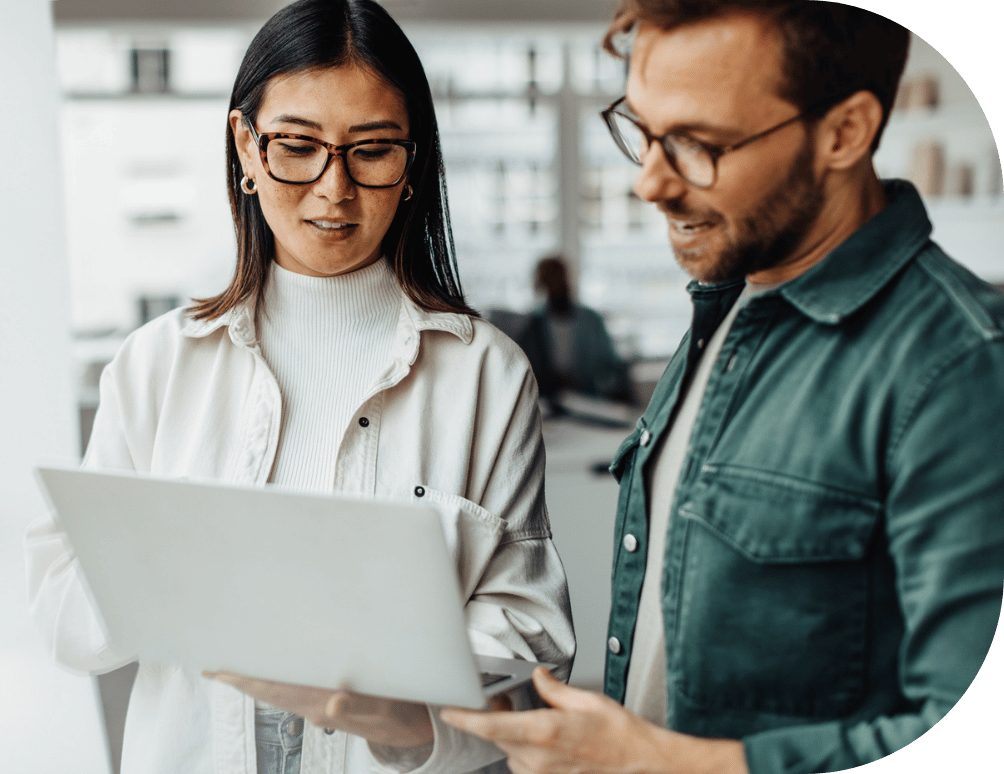 Two professionals talking and looking at a laptop