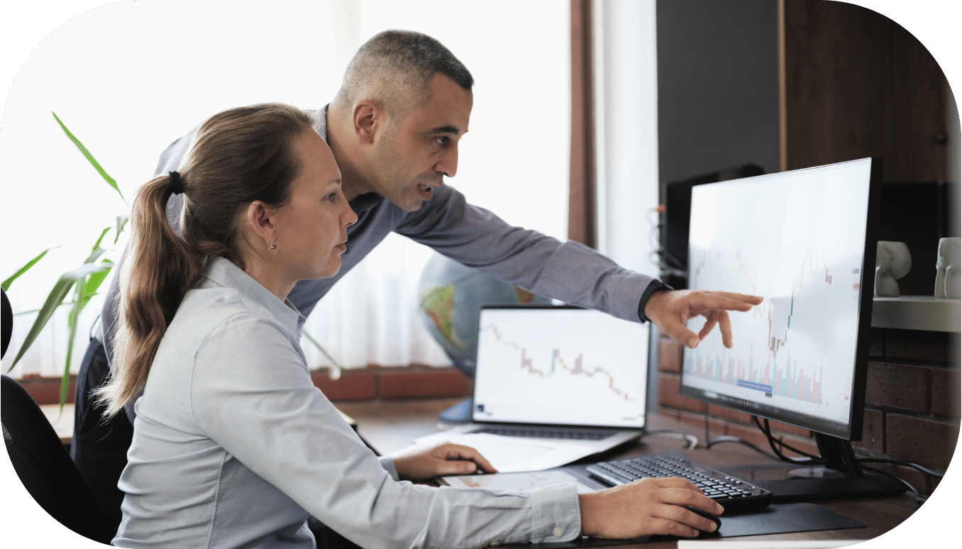 Two coworkers pointing at a computer screen