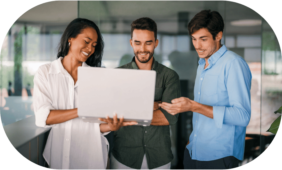Three coworkers looking at a laptop