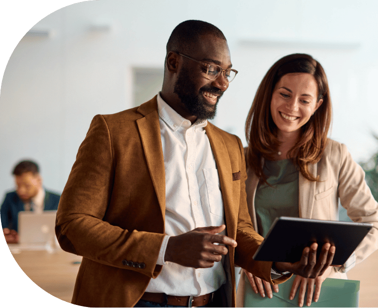 Two coworkers talking over a tablet