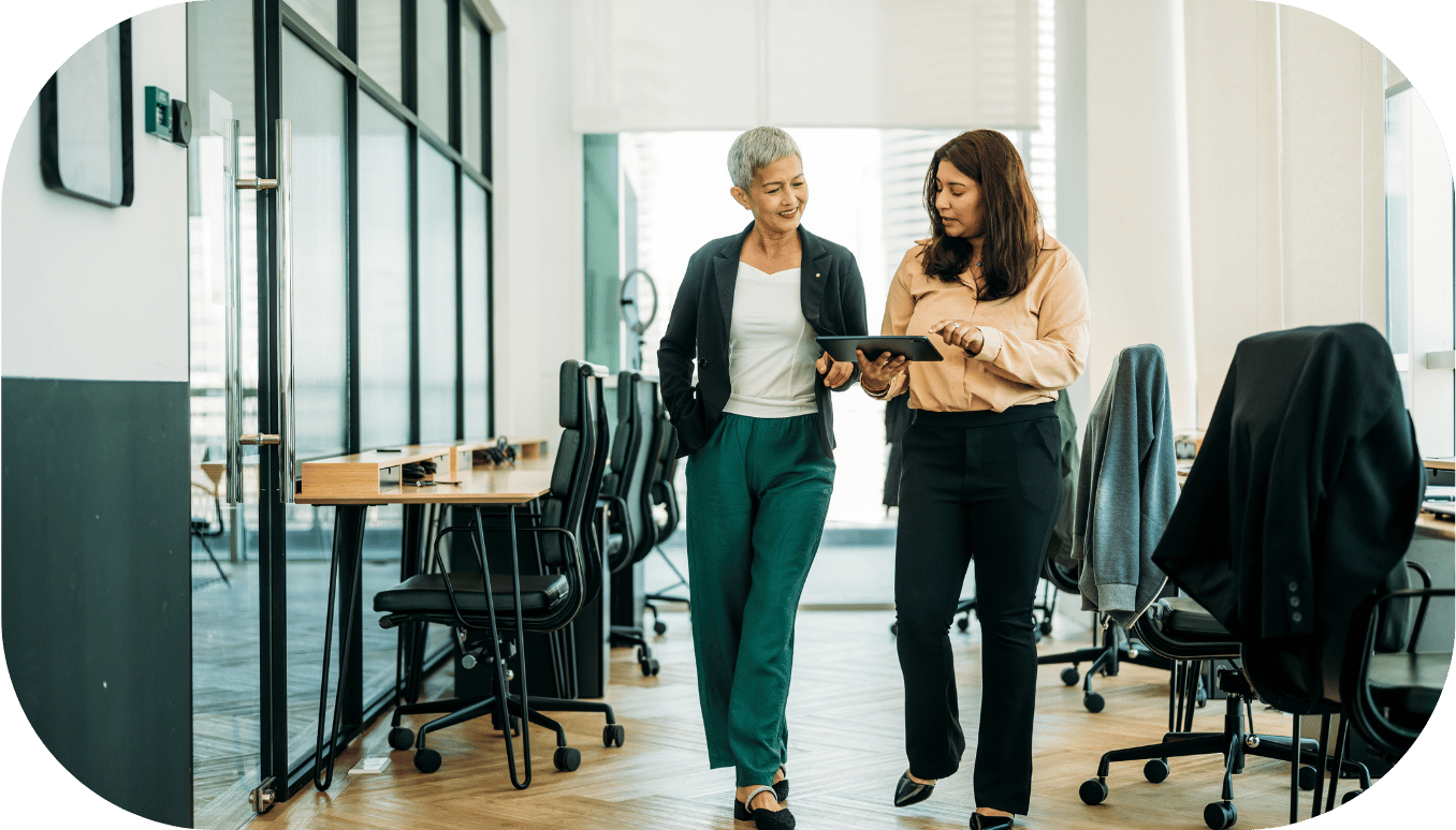 Two women walking down an office hallway