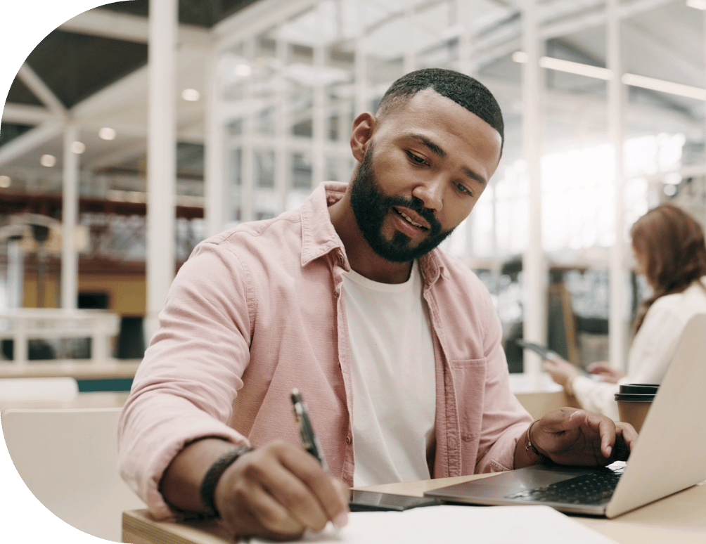 A man with a laptop taking notes