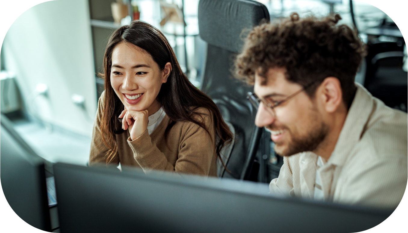 Two coworkers looking at a desktop