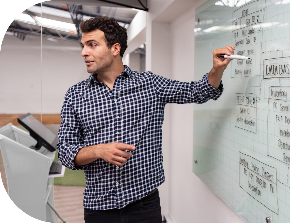 A man pointing to a white board